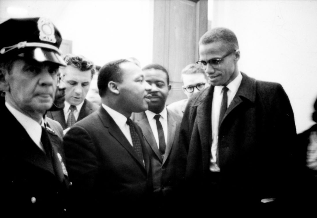 Martin Luther King and Malcolm X speak briefly before a Senate hearing on the Civil Rights Act, March 1964. This was the only time the two met. (<a href="https://commons.wikimedia.org/wiki/File:MartinLutherKingMalcolmX.jpg">Wikimedia Commons</a>)